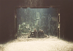 The three main characters from "Stalker" sit in a hallway, which is being flooded by rain.